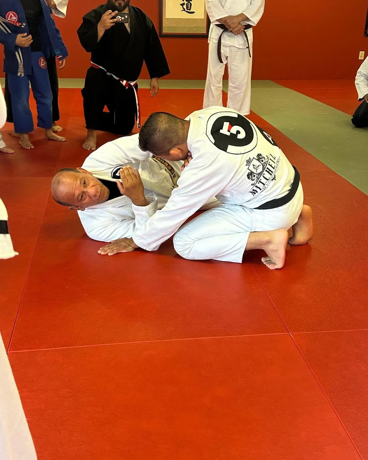 Two adults rolling during Brazilian Jiu-Jitsu class at Samurai Dojo
